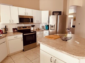 Kylskåp, mikrovågsugn, kaffe- och tebryggare och grytor/köksredskap