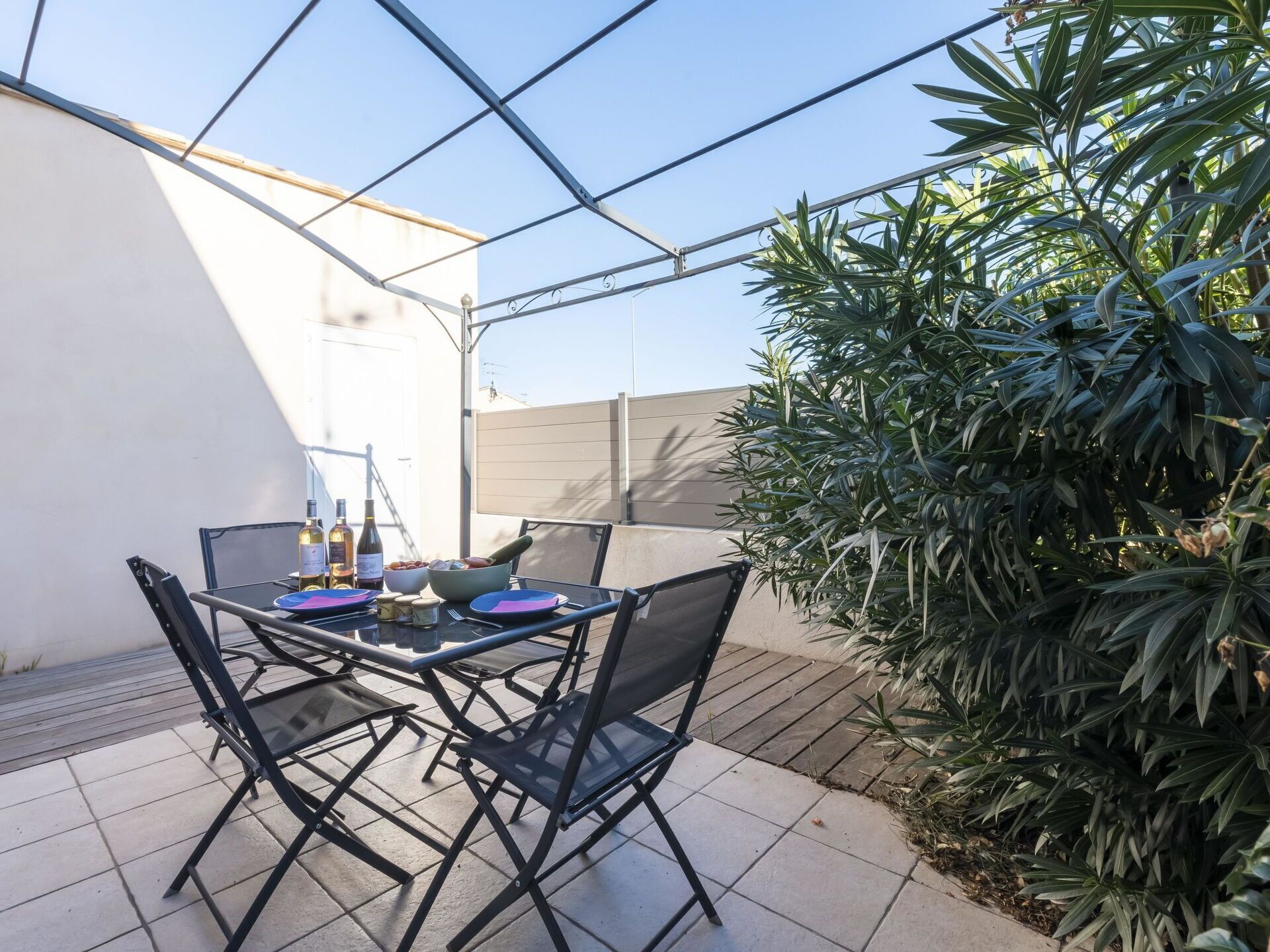 Un patio al aire libre con una mesa lista para comer, rodeado de sillas.