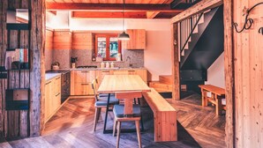 A rustic wooden interior with a central wooden table and benches, a kitchen area with a window, and a staircase. - Wonderful private villa for 6 guests with TV and pets allowed (Massimeno)