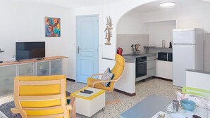 A compact living space with a kitchenette, a dining area, and a TV. - Cosy apartment for 3 guests with WIFI and TV (Six-fours-les-plages)
