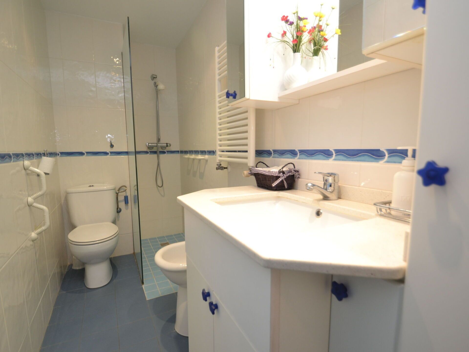 A bathroom with a toilet, shower, and sink.