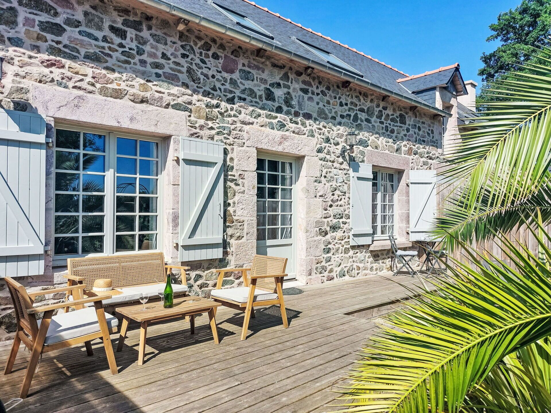 A stone building with wooden deck and outdoor seating.