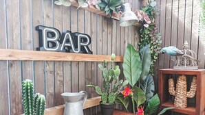 A wooden wall with a 'BAR' sign, a metal pitcher, a cactus, and various plants. - Beautiful  villa for 3 people with WIFI, TV and patio (Petit Saint-malo)