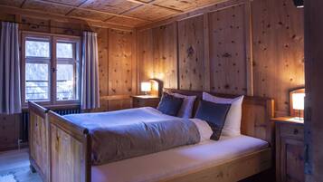 Ein Zimmer mit Holzboden, einem Bett, zwei Nachttischen und einem Fenster.