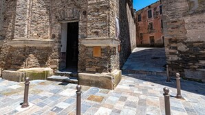 A stone building with a doorway and a small balcony.