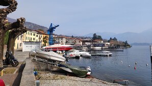 A marina with boats docked, a crane, and buildings in the background. - Cosy apartment for 4 guests with A/C, WIFI, TV, terrace and pets allowed (Mezzegra)