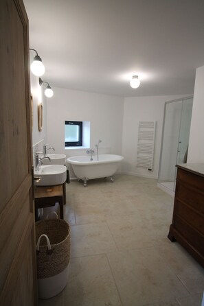 A bathroom with two sinks, a bathtub, and a wooden cabinet. - La Maison Bois Carré Idéale Pour des Vacances en Famille ou Entre Amis ! (Saint-Yzans-de-Médoc)