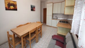 Eine kompakte Küche mit Essbereich, einer Couch und einem Gemälde von einem Pferd.