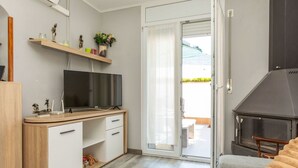 Een moderne slaapkamer met een televisie, een houten bureau en een open haard.