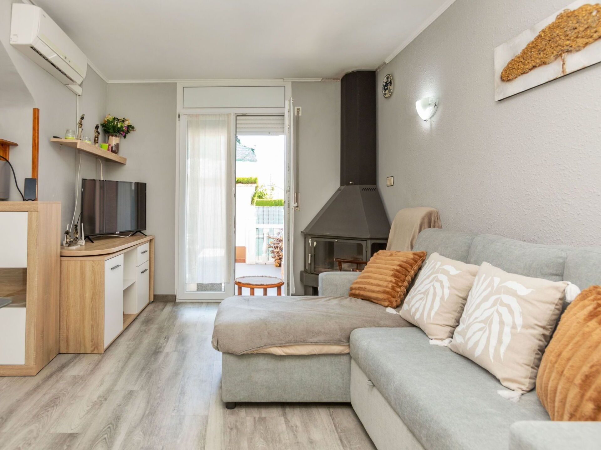 Een moderne woonkamer met een bank, een televisie, een haard en een keuken.
