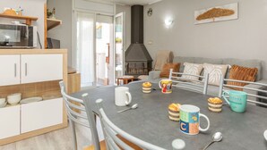 Een moderne keuken met een eethoek, een open haard en uitzicht op de omgeving.