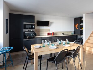 A modern kitchen with a dining area set for a meal.