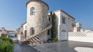 Ein Steinturm, an ein Gebäude angebaut, mit einer Treppe zum Eingang.