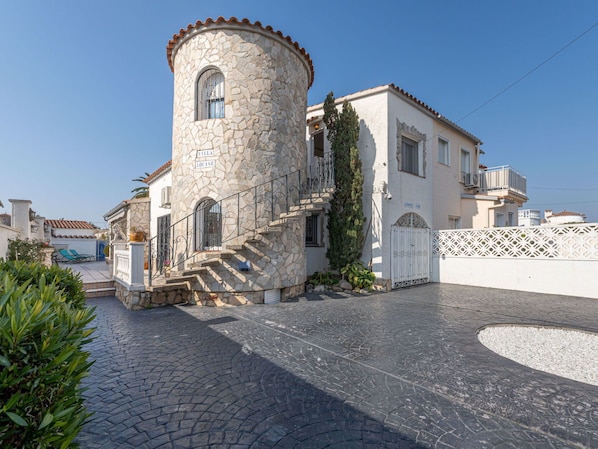 A stone tower attached to a building with a staircase leading to the entrance.