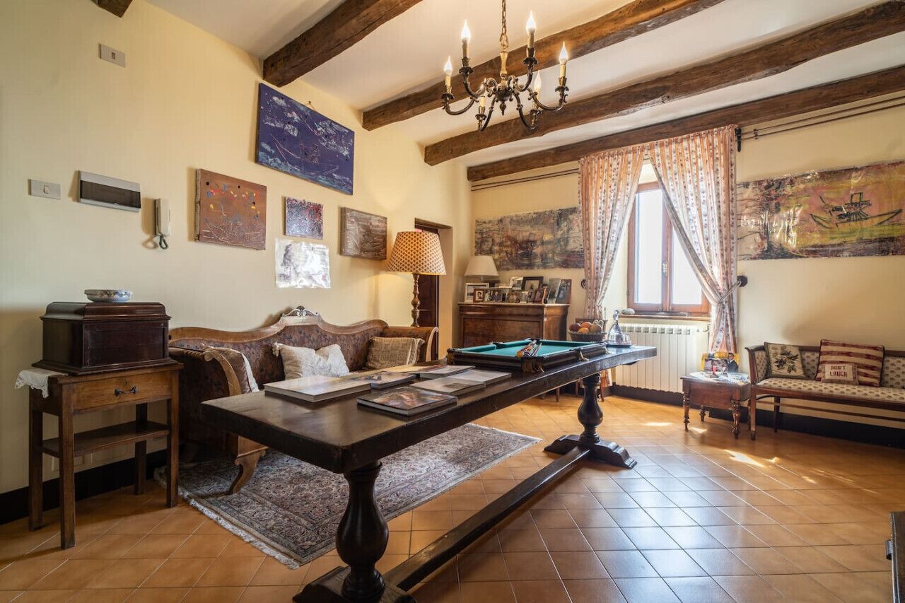 A cozy living room with a billiards table, wooden furniture, and artwork on the walls.