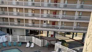 A hotel with a pool area, multiple balconies, and outdoor seating.
