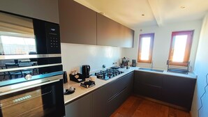 A modern kitchen with a built-in oven, a coffee maker, and a sink. - [10 minutes from city center] Luxury Penthouse with Terrace and Panoramic View (Roma)