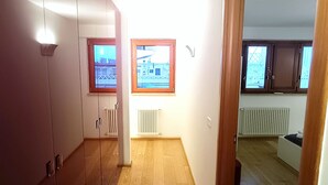 A hallway with wooden flooring, a radiator, and a door leading to another room. - [10 minutes from city center] Luxury Penthouse with Terrace and Panoramic View (Roma)
