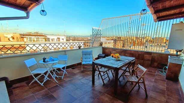 A balcony with a table, chairs, and a flower vase. - [10 minutes from city center] Luxury Penthouse with Terrace and Panoramic View (Roma)