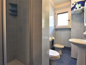 A bathroom with a shower, two toilets, a sink, and a window. - Nice apartment for 5 people with WIFI, TV and terrace (Aprica)