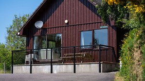 A wooden building with a balcony and a satellite dish. - Nice apartment in villa for 6 guests with WIFI, TV, patio and panoramic view (Inverness)