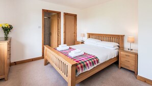 A bedroom with a wooden bed, a nightstand, a dresser, and a wardrobe. - Nice apartment in villa for 6 guests with WIFI, TV, patio and panoramic view (Inverness)