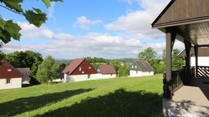 Ein Wohngebiet mit Häusern, einem Rasen und einer Holzhütte mit Veranda.