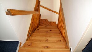 Eine Holztreppe mit Handlauf und einer Zwischenebene.