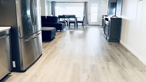 Una cocina moderna con un refrigerador de acero inoxidable, un comedor con mesa y sillas, y un ventilador de techo.