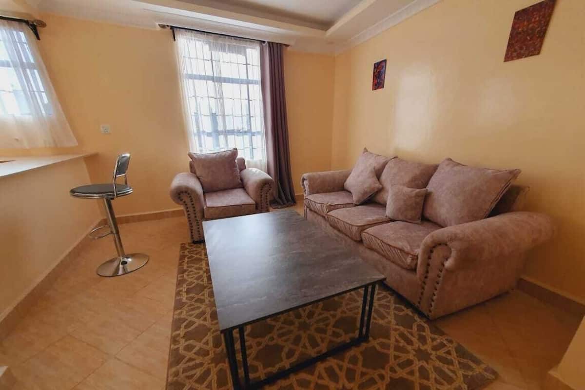Uma sala de estar com sofá, mesa de centro e poltrona.