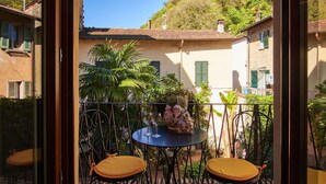 A terrace with two chairs and a table, overlooking a hillside with buildings.