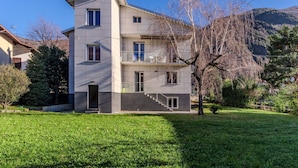 A modern two-story building with a flat roof, multiple windows, and a staircase leading to the upper floor. - Lovely apartment in villa for 12 guests with A/C, WIFI, TV, patio and pets allowed (Dervio)