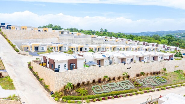 A residential area with modern apartment buildings, a landscaped garden with a geometric design, and a clear view of the surrounding landscape. - Your cool oasis home away from home. Breath taking views for relaxation  (Ocho Rios)