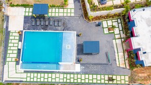 An aerial view of a swimming pool area with a rectangular pool, lounge chairs, and a covered seating area. - Your cool oasis home away from home. Breath taking views for relaxation  (Ocho Rios)