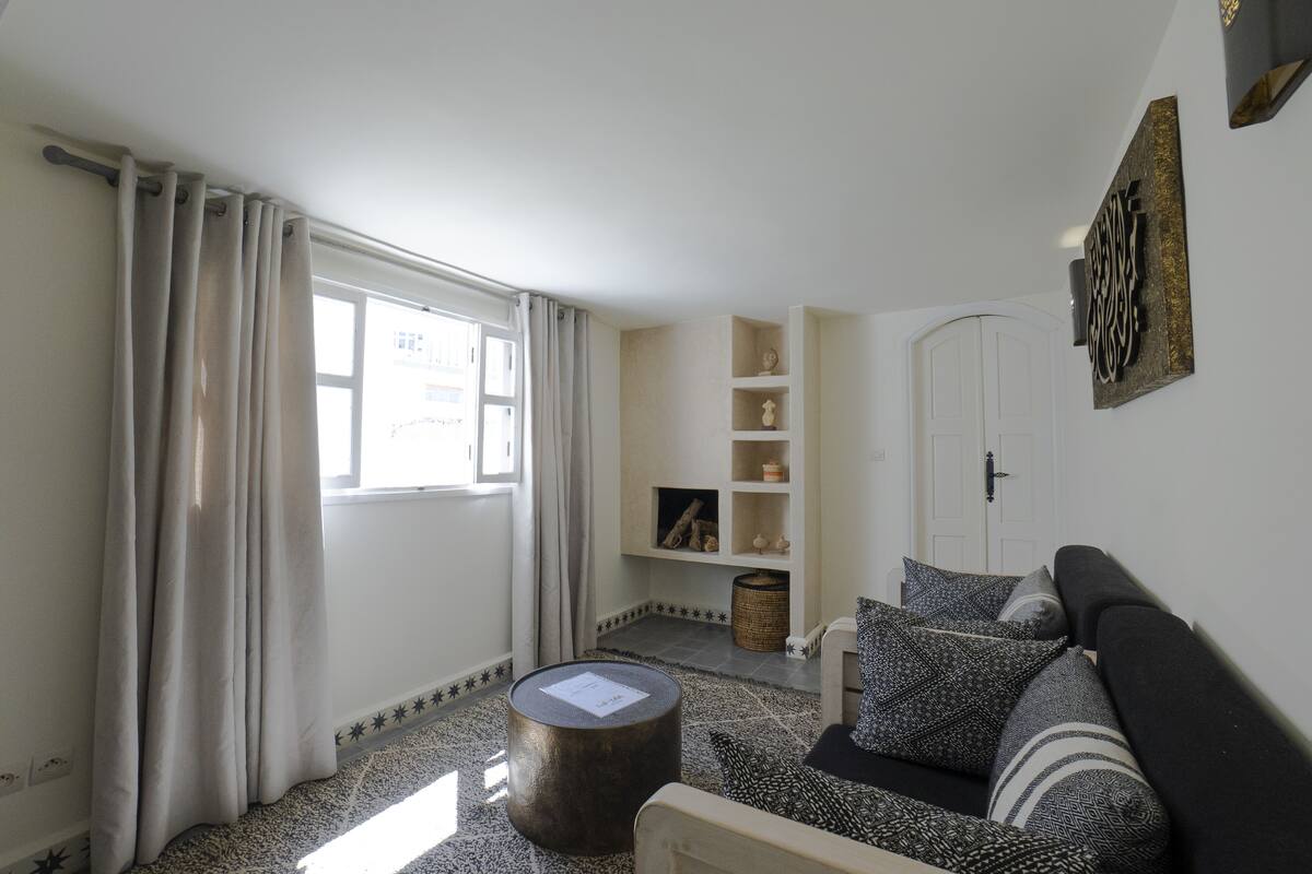 A living room with a sofa, a round coffee table, and a bookshelf.