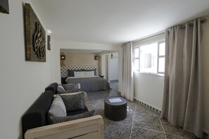 Un dormitorio moderno con cama, sofá y una pequeña mesa.