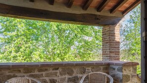An outdoor seating area with two wicker chairs and a stone wall backdrop. - Wonderful private villa for 10 guests with WIFI, private pool, TV, pets allowed and panoramic view (Civitella In Val Di Chiana)