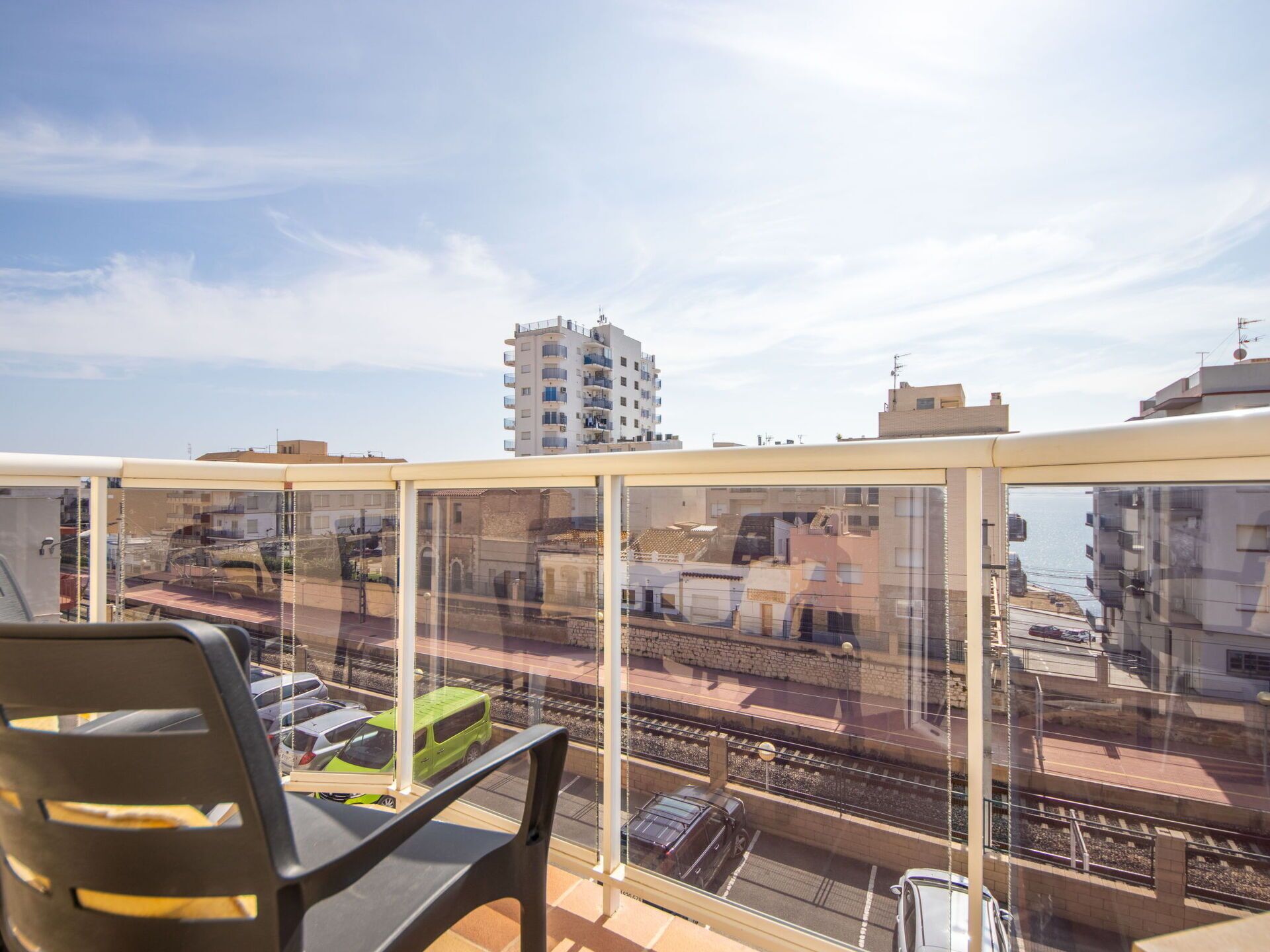 A balcony with a view of a train track and buildings.
