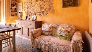 Une pièce chaleureuse avec une table en bois, un canapé à motifs et une tapisserie accrochée au mur.