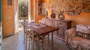 Un comedor con mesa y sillas de madera, un aparador buffet y una pared de piedra.