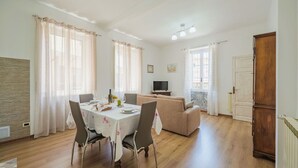 A spacious living area with a dining table set for four, a sofa, a television, and a wooden cabinet. - Stunning  villa for 2 people with WIFI, TV and terrace (Massa)