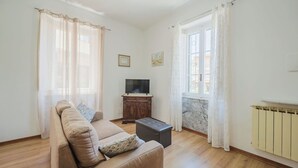 A living room with a sofa, a coffee table, a TV, and a radiator. - Stunning  villa for 2 people with WIFI, TV and terrace (Massa)