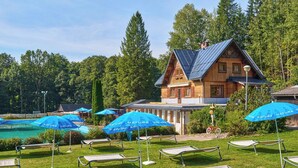 Eine Holzhütte mit Pool und Sitzgelegenheit im Freien.