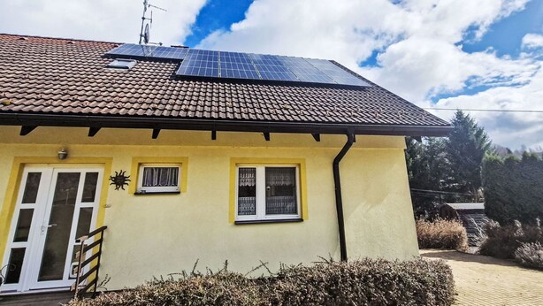 A yellow house with a tiled roof, solar panels, and a small garden. - Nice apartment for 4 people with WIFI, TV, patio and pets allowed (Dvur Králové Nad Labem)