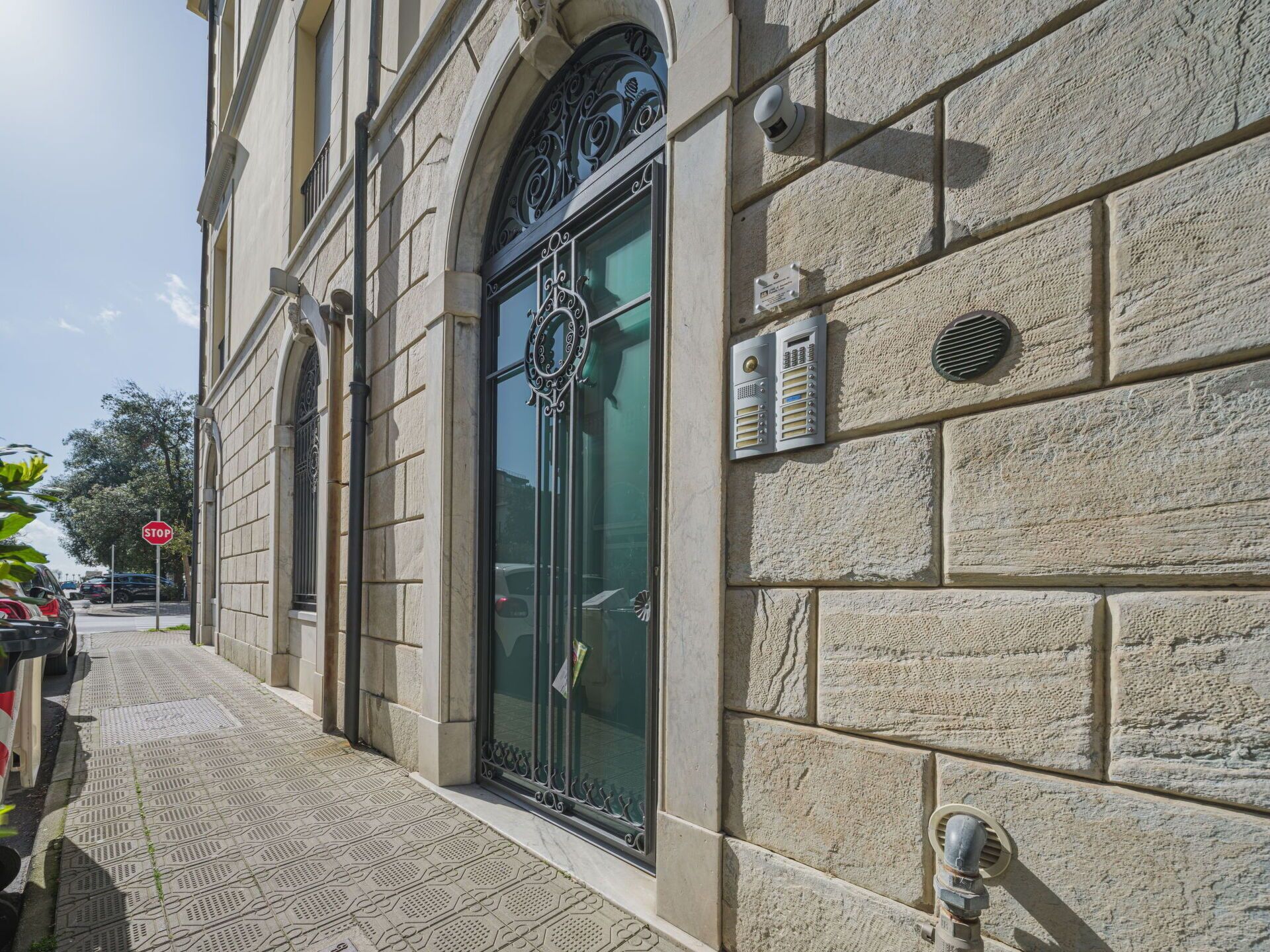 A building facade with a large arched entrance, a stop sign, and a fire hydrant.