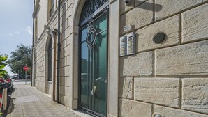 Fachada de prédio com uma grande entrada em arco, uma placa de parada e um hidrante.