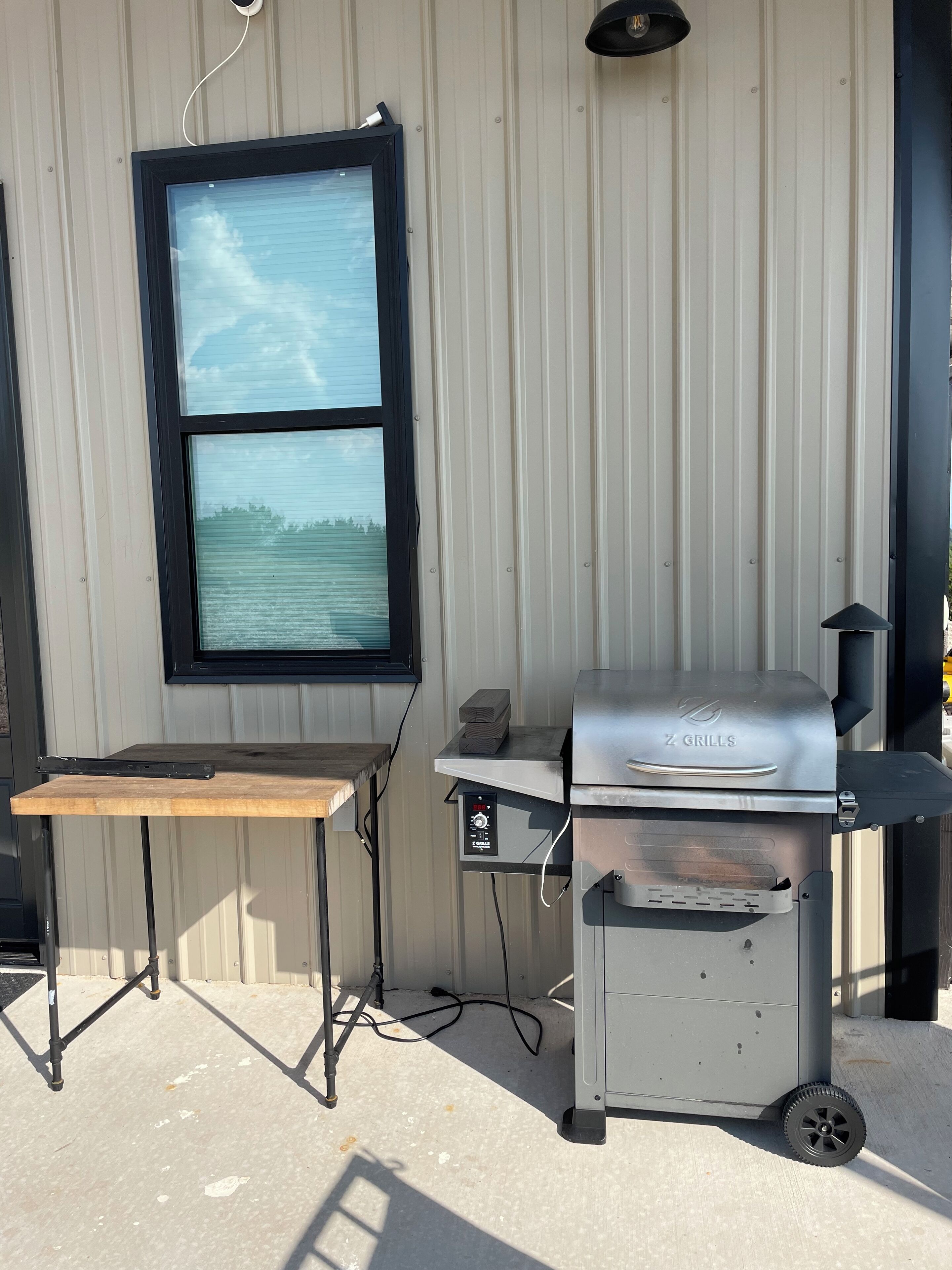 Ein tragbarer Grill mit Bedienfeld, Tisch und Fenster mit Blick auf das Wasser.