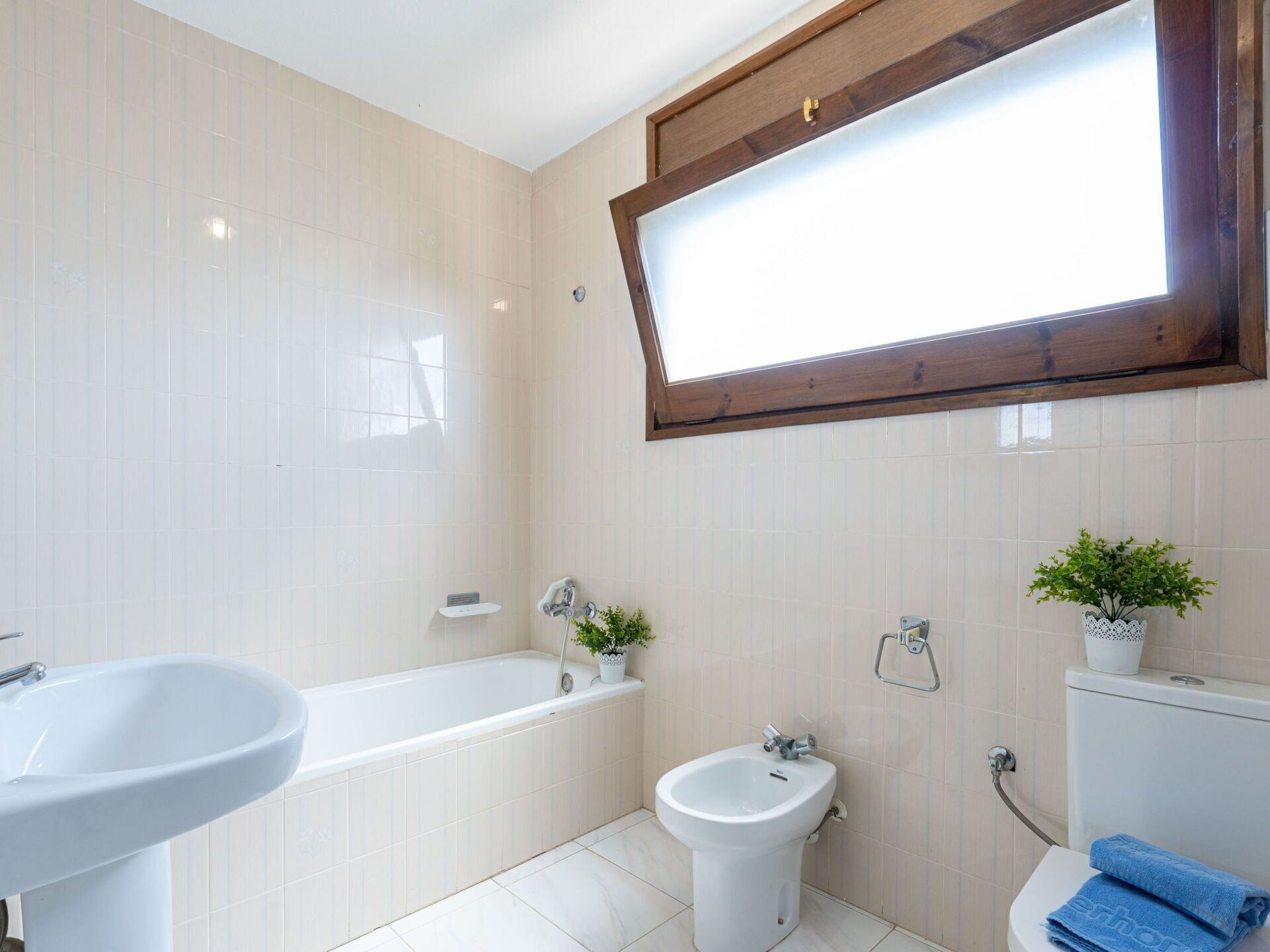 Een badkamer met een bad, een toilet, een wastafel en een bidet.