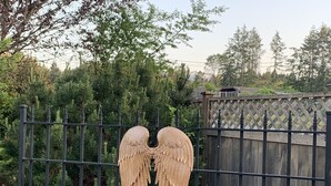 Une porte en métal, agrémentée d’une clôture en bois et d’une statue d’ange décorative.