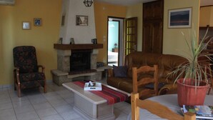 Ein Wohnzimmer mit Kamin, einer Couch, einem Sessel und einem Couchtisch.